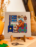 Reading by the Fire cross stitch pattern by NeedleLot Designs, a bear reading by the fire