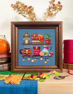 Cozy Autumn Shelves cross stitch pattern by NeedleLot Designs, shelves with books, a cat, candle, pumpkin and mushroom