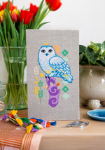 Snowy Owl cross stitch pattern by NeedleLot Designs, a snowy owl on a purple stump