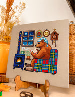 Reading by the Fire cross stitch pattern by NeedleLot Designs, a bear reading by the fire