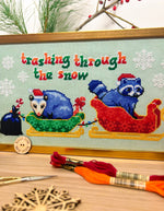Trashing Through The Snow cross stitch pattern by NeedleLot Designs, raccoons in a sleigh in the snow