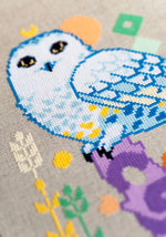 Snowy Owl cross stitch pattern by NeedleLot Designs, a snowy owl on a purple stump