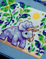 Triceratops cross stitch pattern by NeedleLot Designs, a triceratops in a prehistoric jungle