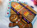 Closeup of Cookies & Scream gingerbread man. Details are clearly visible. Stitches are neat and tidy. Windows are fiery and have blood dropping down them. Candycanes are bright purple and black, and very shiny. Frosting is on the roof, with smarties