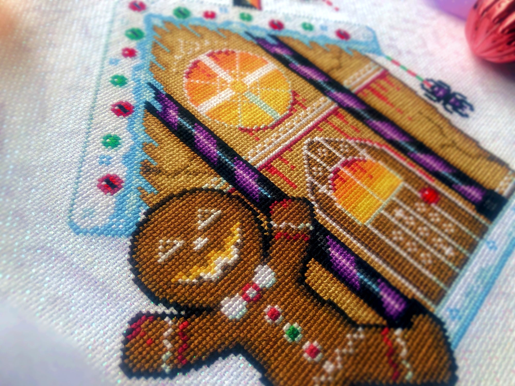 Closeup of Cookies & Scream gingerbread man. Details are clearly visible. Stitches are neat and tidy. Windows are fiery and have blood dropping down them. Candycanes are bright purple and black, and very shiny. Frosting is on the roof, with smarties