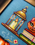 Cozy Autumn Shelves cross stitch pattern by NeedleLot Designs, shelves with books, a cat, candle, pumpkin and mushroom