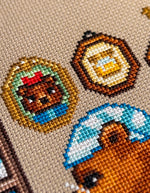 Reading by the Fire cross stitch pattern by NeedleLot Designs, a bear reading by the fire