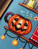 Cozy Autumn Shelves cross stitch pattern by NeedleLot Designs, shelves with books, a cat, candle, pumpkin and mushroom
