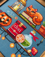 Cozy Autumn Shelves cross stitch pattern by NeedleLot Designs, shelves with books, a cat, candle, pumpkin and mushroom